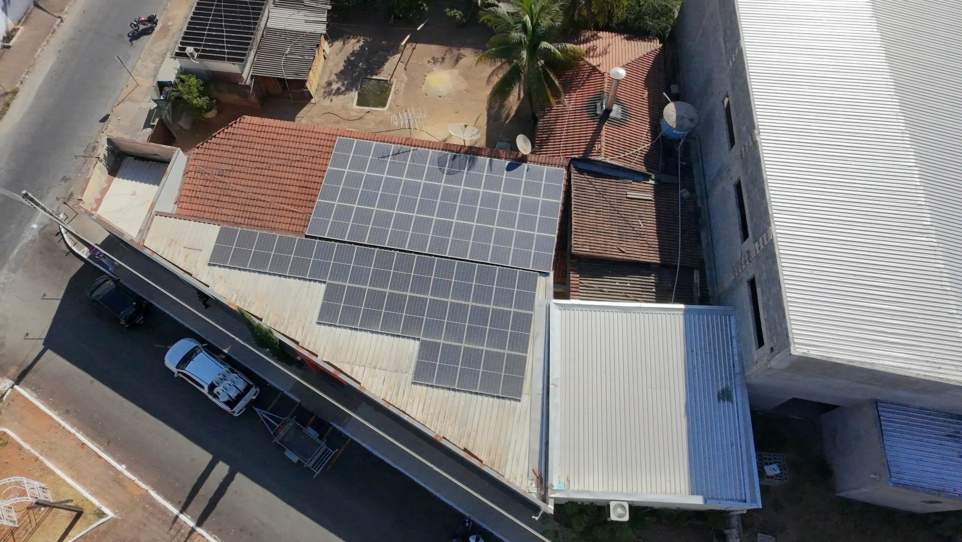 Vista aérea de um telhado com módulos fotovoltaicos instalados, no voo de julho de 2026